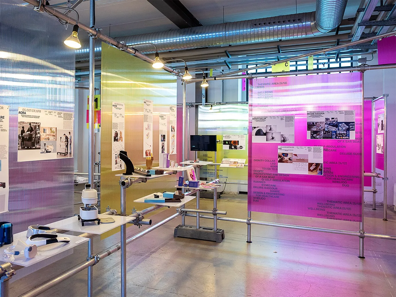 Exhibition tables with objects and magenta panels with images